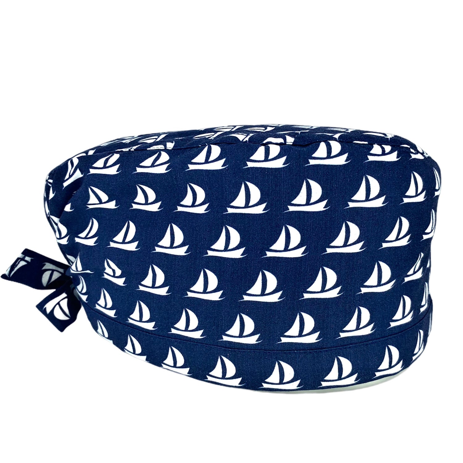 Cuffietta chirurgica blu con piccole barchette a vela bianche stilizzate e organizzate in un elegante pattern geometrico