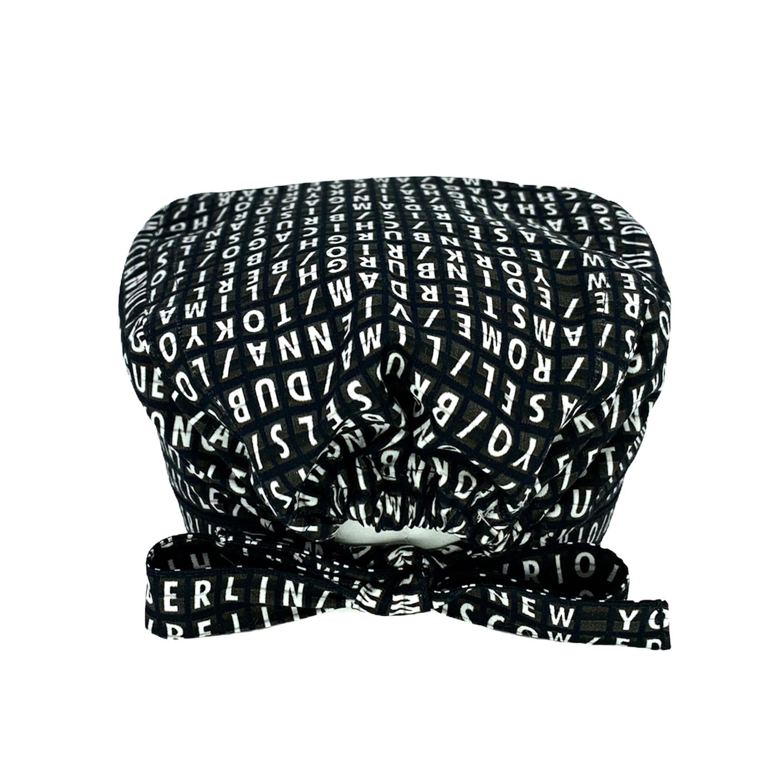 Cuffietta chirurgica con scritte bianche su fondo nero, come un vecchio tabellone aeroportuale, le capitali del mondo si alternano in una lista infinita di posti da visitare.