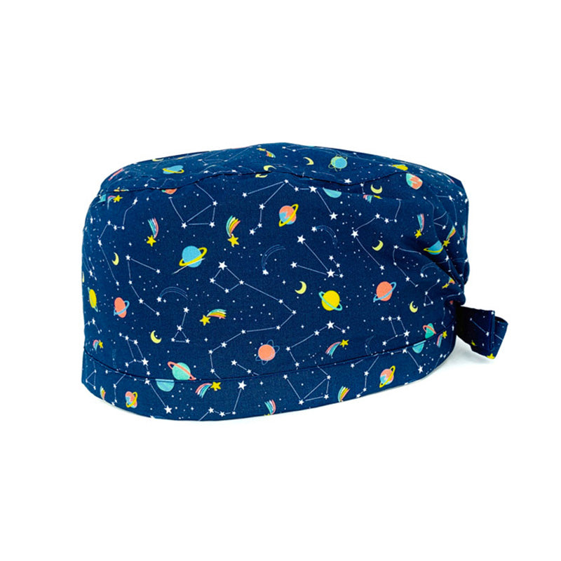 Cuffietta chirurgica con mille micro stelline compongono fantasiose costellazioni, insieme a stelle comete dalla coda variopinta e improbabili pianeti color caramella! sfondo blu