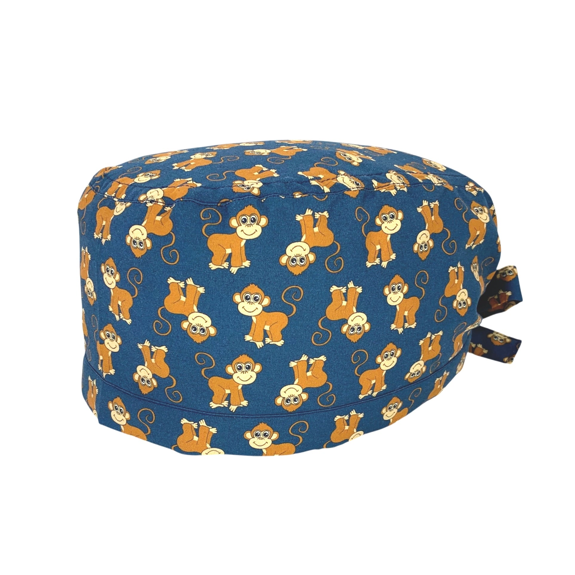 Cuffietta chirurgica con simpatiche scimmiette marroni, sorridenti e con la coda lunga arricciata, alternate a testa in giù o diritte; sfondo blu
