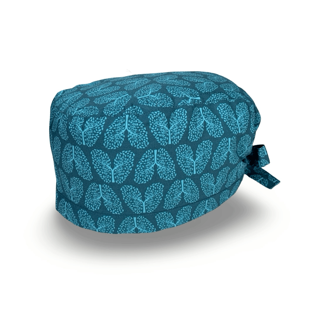 Un pattern elegante per questa cuffietta chirurgica che riproduce la struttura dell'albero bronchiale trasformandolo in piccole foglioline come se fosse un vero albero, tono su tono in blu e viola. Un richiamo alla salute dei nostri polmoni e alla natura.
