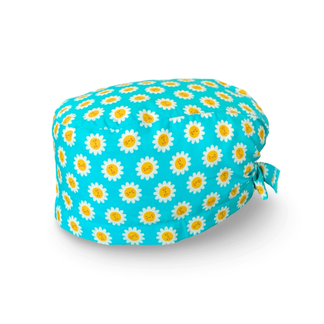 La bellezza di questa cuffietta chirurgica sta nella sua semplicità e nell'esplosività dei colori: piccole margherite con faccine sorridenti su sfondo lilla o turchese.