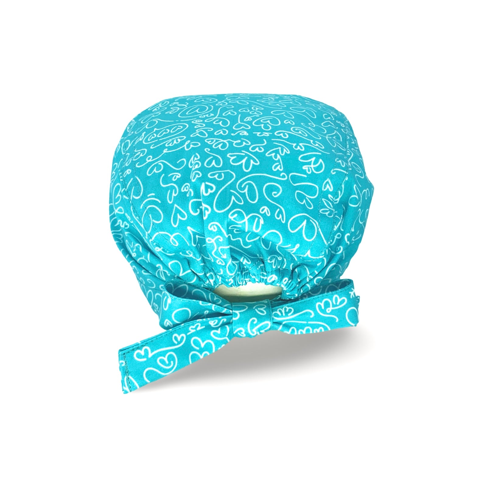 Un'elegantissima fantasia per questa cuffietta chirurgica, tappezzata di cuoricini scarabocchiati a mano con un tratto bianco su base tinta unita lilla, fucsia o turchese.