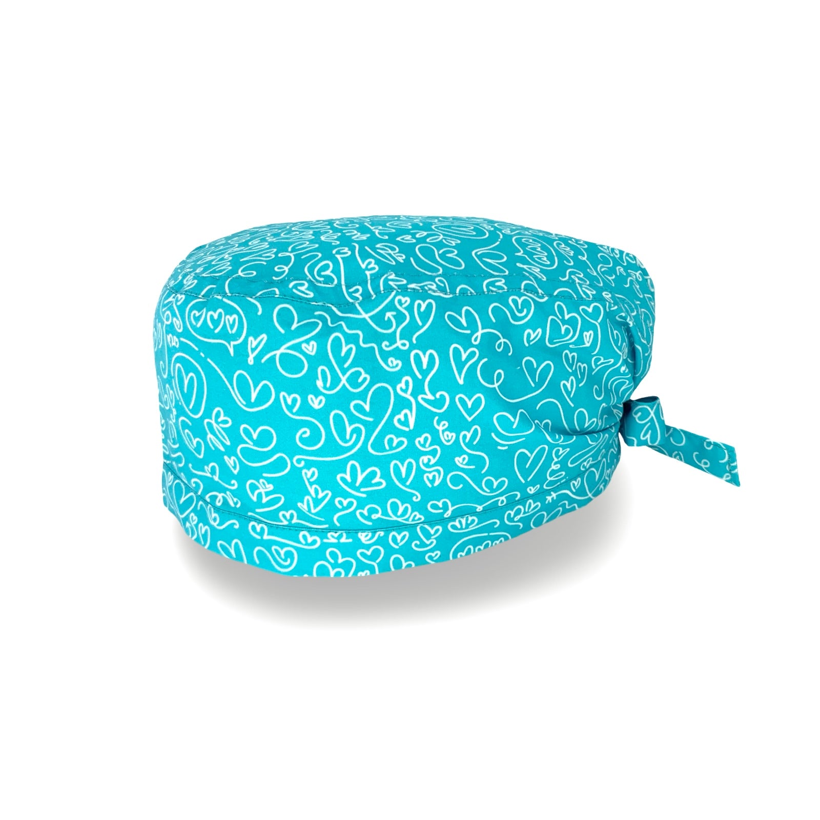 Un'elegantissima fantasia per questa cuffietta chirurgica, tappezzata di cuoricini scarabocchiati a mano con un tratto bianco su base tinta unita lilla, fucsia o turchese.