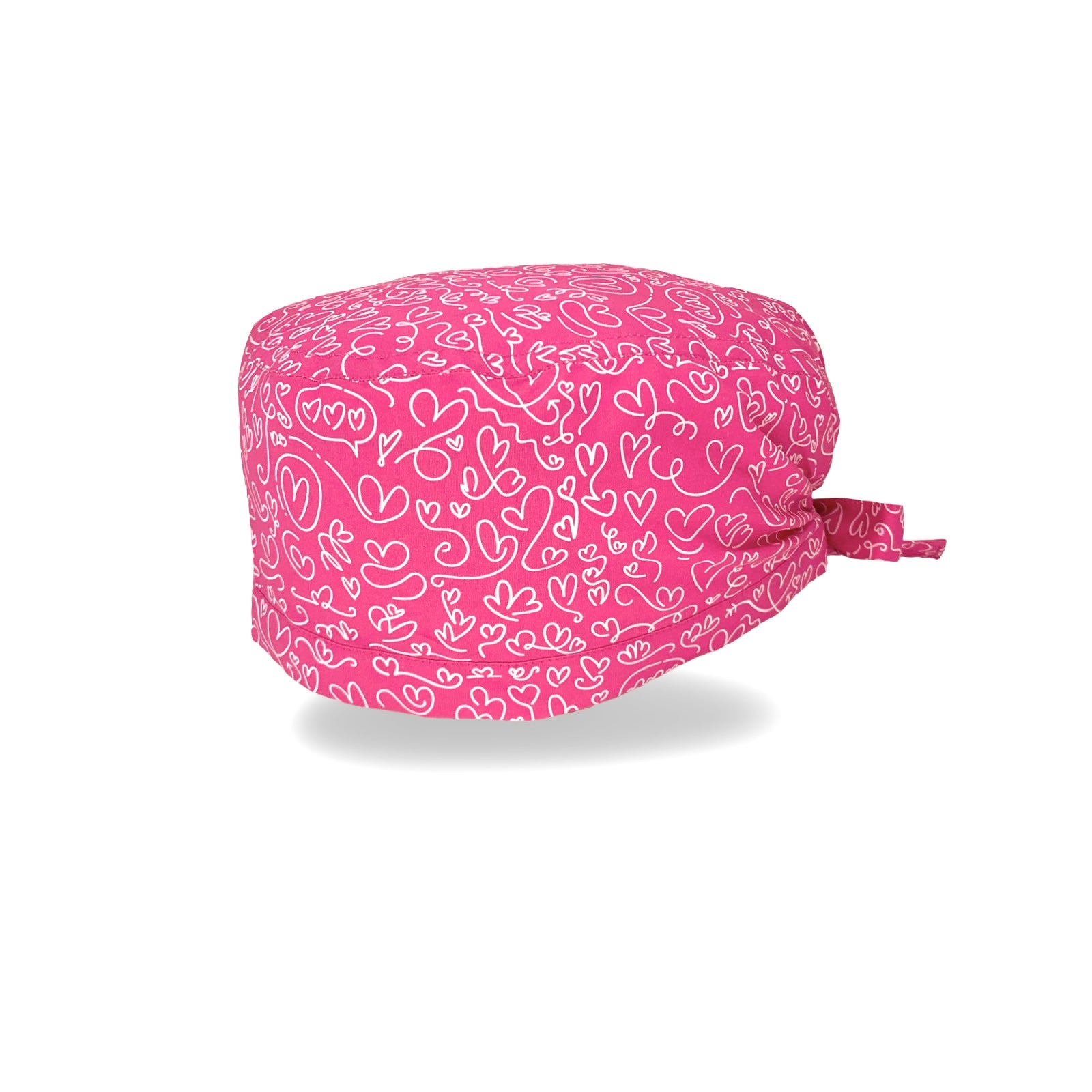 Un'elegantissima fantasia per questa cuffietta chirurgica, tappezzata di cuoricini scarabocchiati a mano con un tratto bianco su base tinta unita lilla, fucsia o turchese.