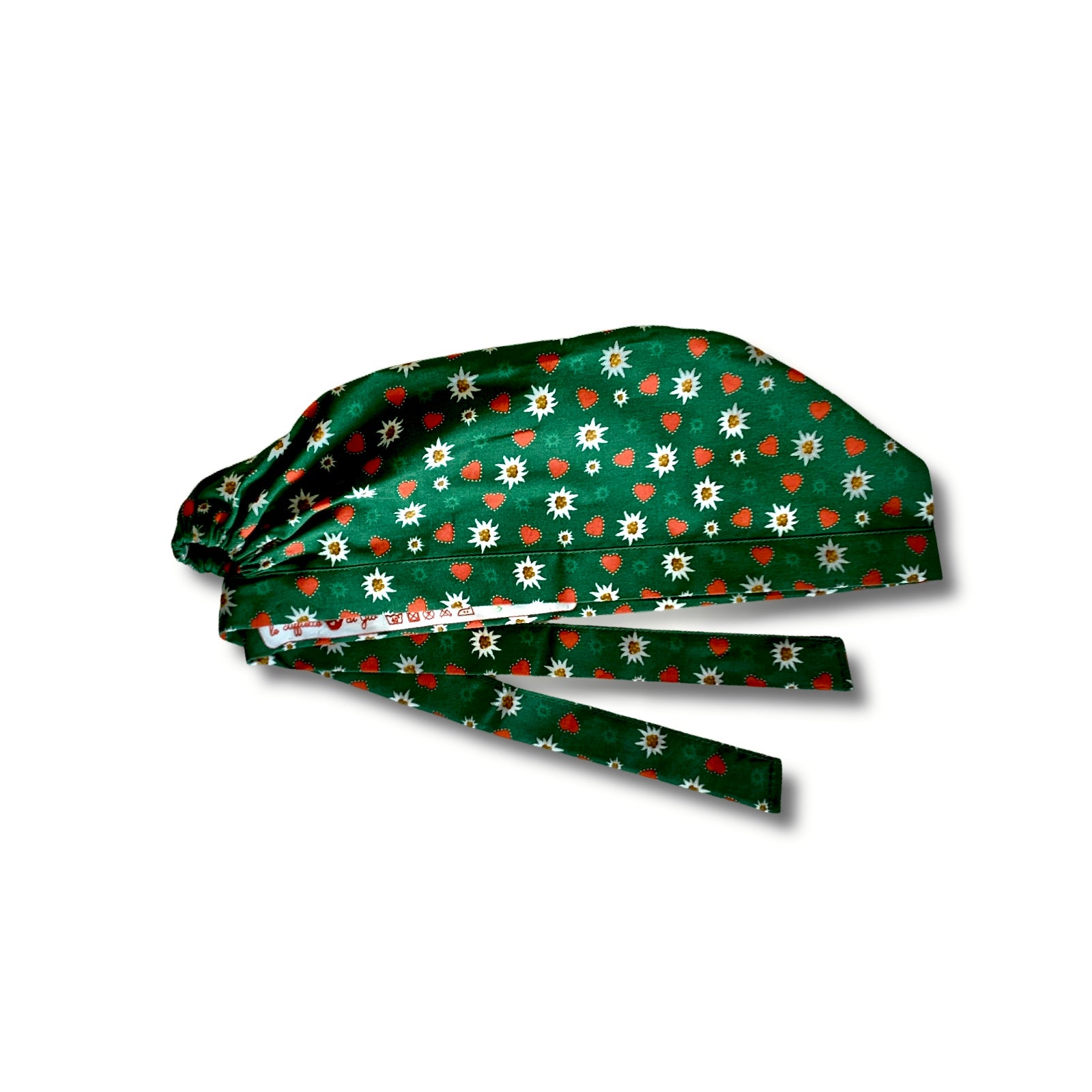 Cuffietta chirurgica a base verde con un pattern di piccole stelle alpine e cuoricini contornati da puntini in pieno stile tirolese