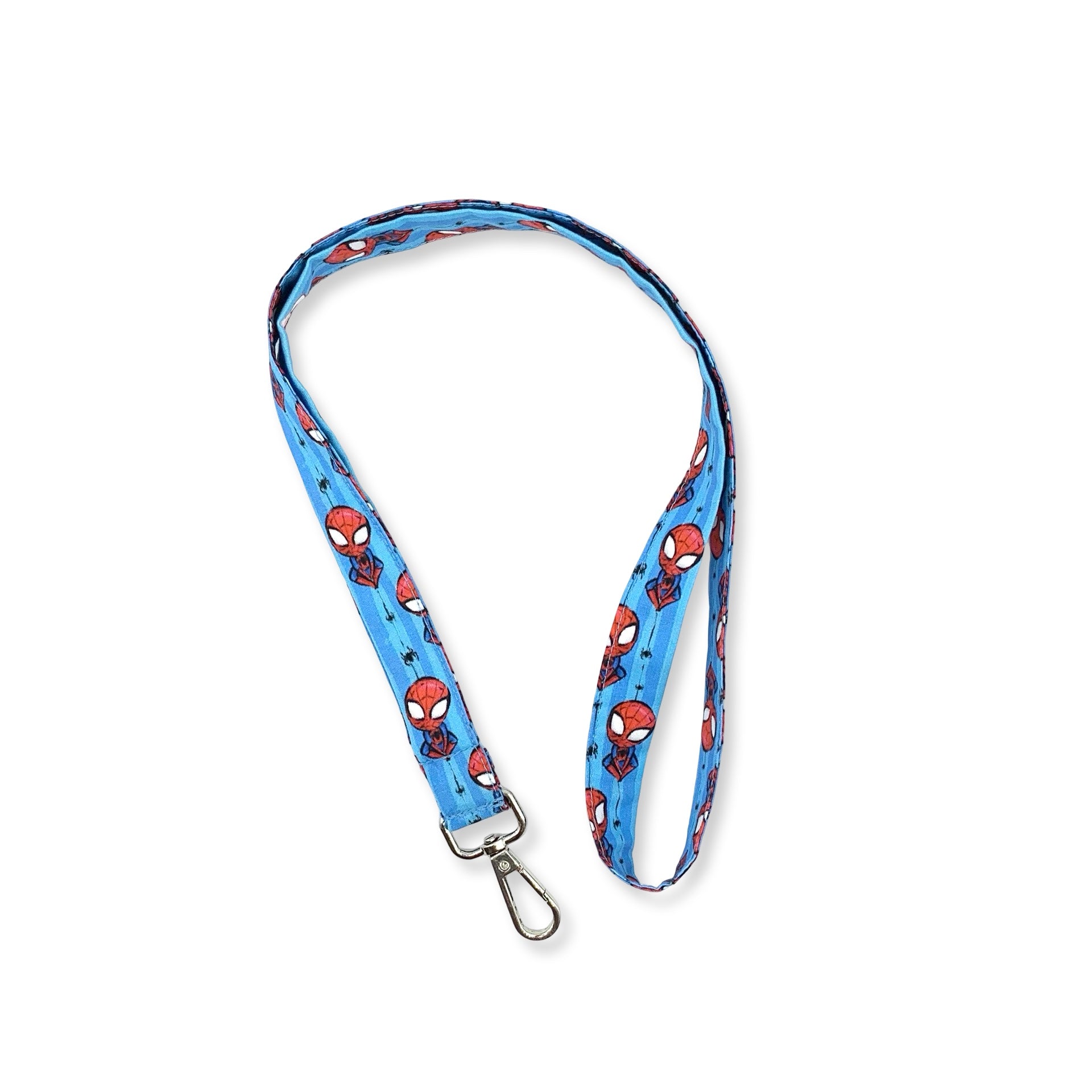Una fascetta da collo portabadge con qualcuno che si arrampica fra le ragnatele… piccoli omini mascherati rossi su sfonfo a righe azzurro chiaro e più scuro. è lunga 45 cm e corredata di moschettone in metallo separabile per il lavaggio grazie al bottone automatico