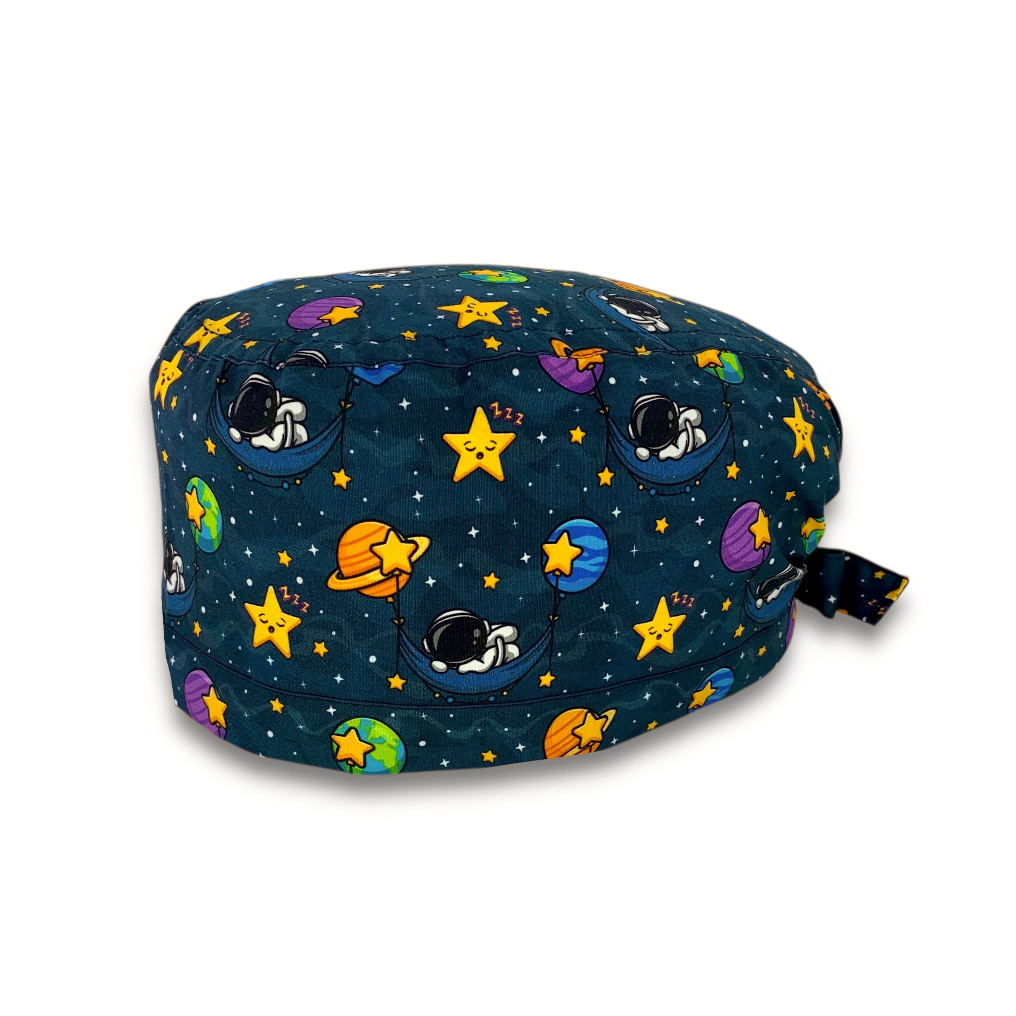 Una cuffietta chirurgica poetica ed evocativa, che parla di spazio, stelle e sogni. Un cielo notturno blu scuro accoglie degli astronauti che dormono su amache appese a pianeti colorati. Il tutto contornato da stelline gialle pisolanti