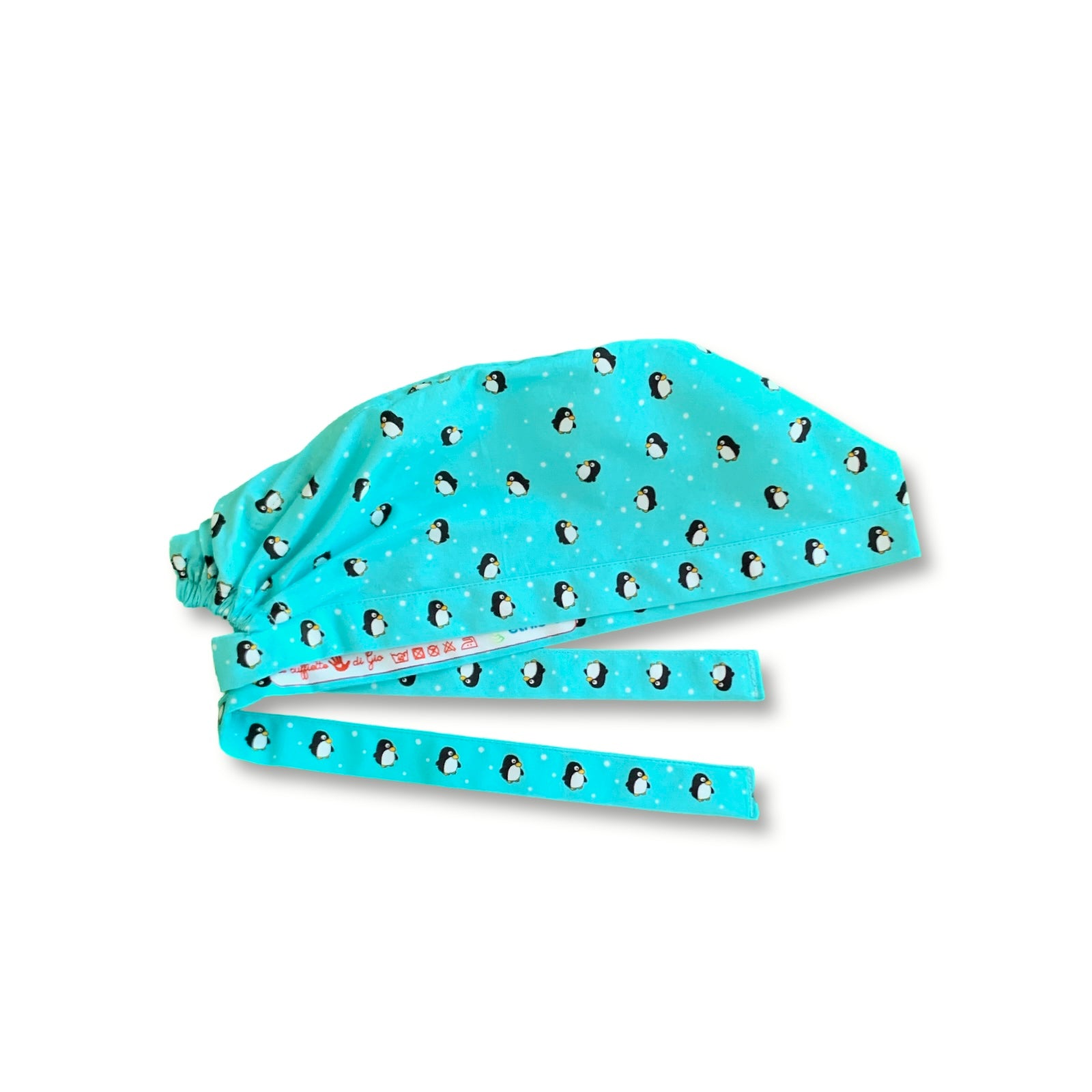 Cuffietta chirurgica con tanti piccoli pinguini si rincorrono su uno sfondo azzurro ghiaccio e tanti fiocchi di neve. L'ideale per gli amanti della stagione invernale.