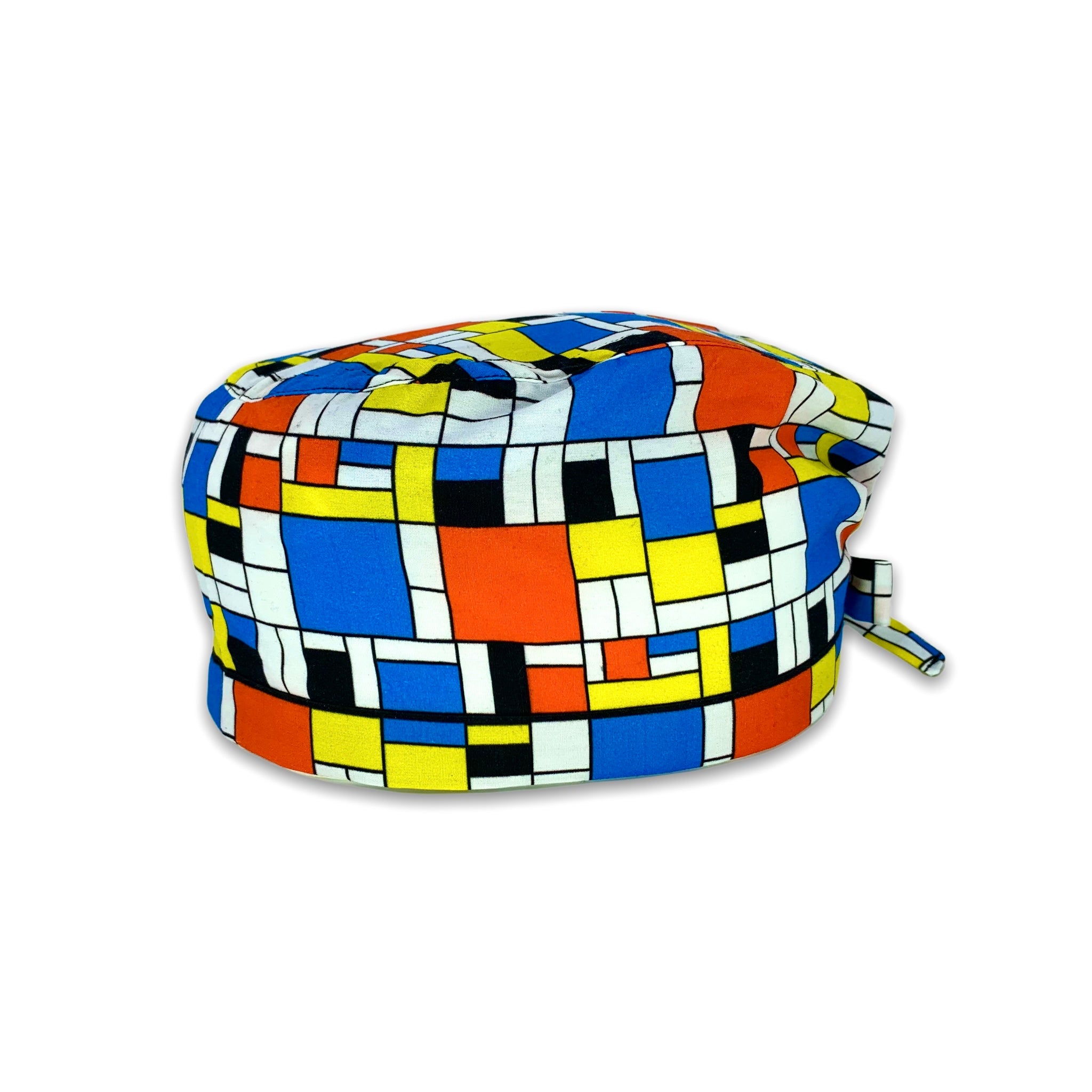 Cuffietta chirurgica che riproduce i disegni geometrici dei quadi di Mondrian, con i colori caratteristici blu, rosso, giallo e nero su  sfondo bianco