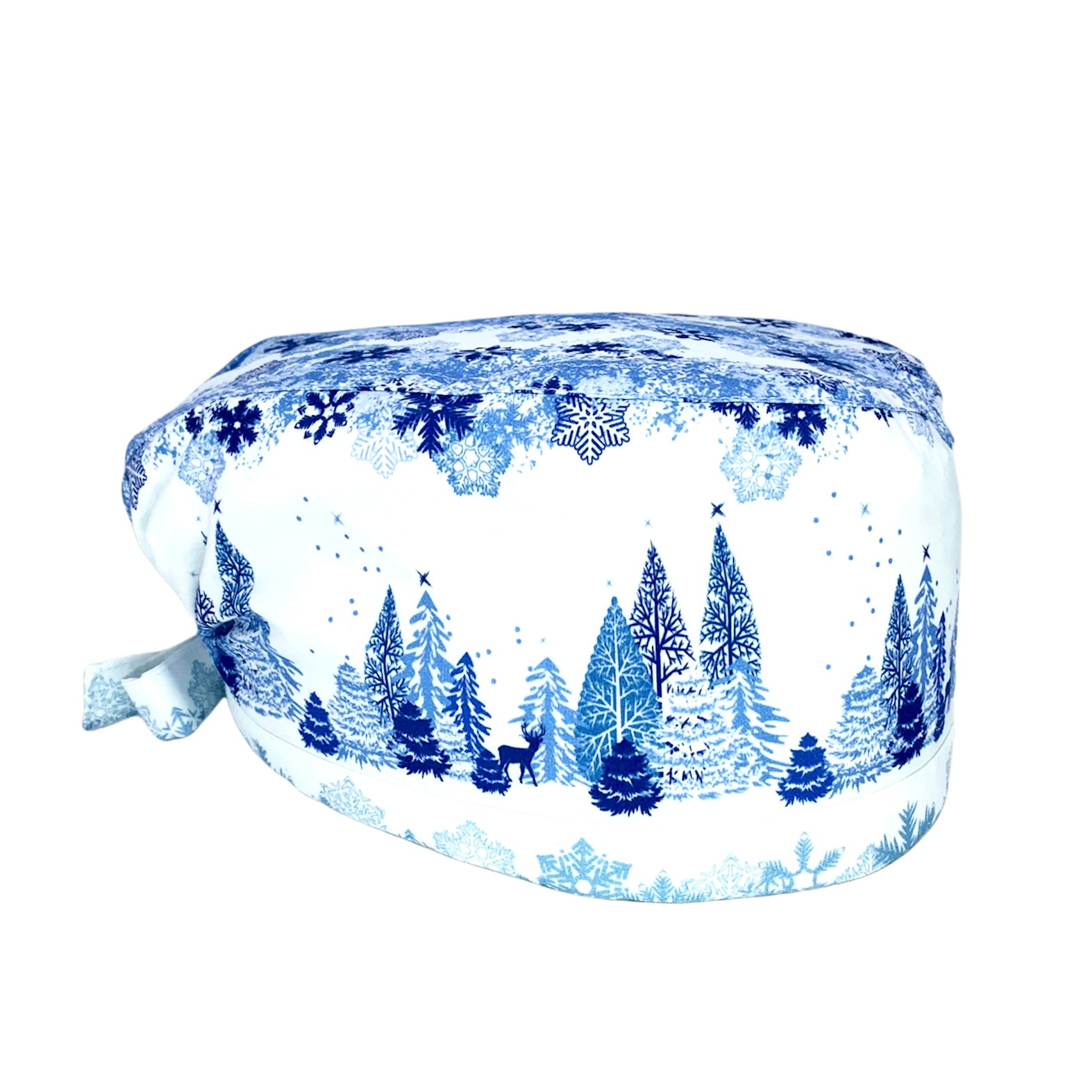 Cuffietta chirurgica bianca con disegni di fiocchi neve in diverse tonalità di blu nella parte superiore einferiore; in mezzo un paesaggio di alberi sotto ai fiocchi di neve con renne che passeggiano indisturbate