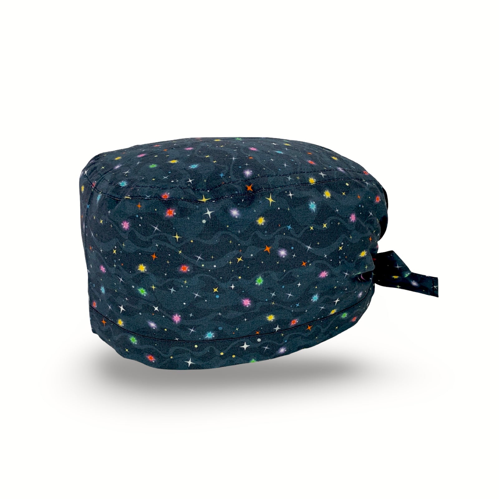 Cuffietta chirurgica con tante piccole stelline colorate che brillano su uno sfondo blu scuro, con onde tono su tono che simulano nubi spaziali.