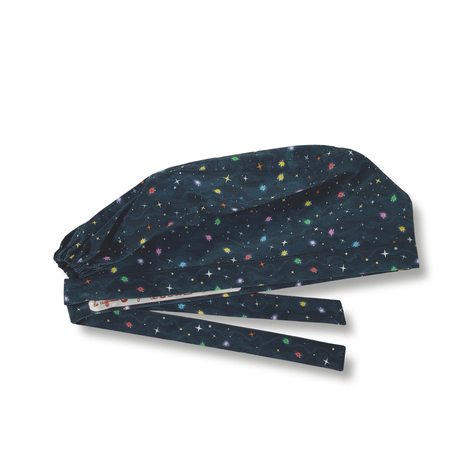 Cuffietta chirurgica con tante piccole stelline colorate che brillano su uno sfondo blu scuro, con onde tono su tono che simulano nubi spaziali.