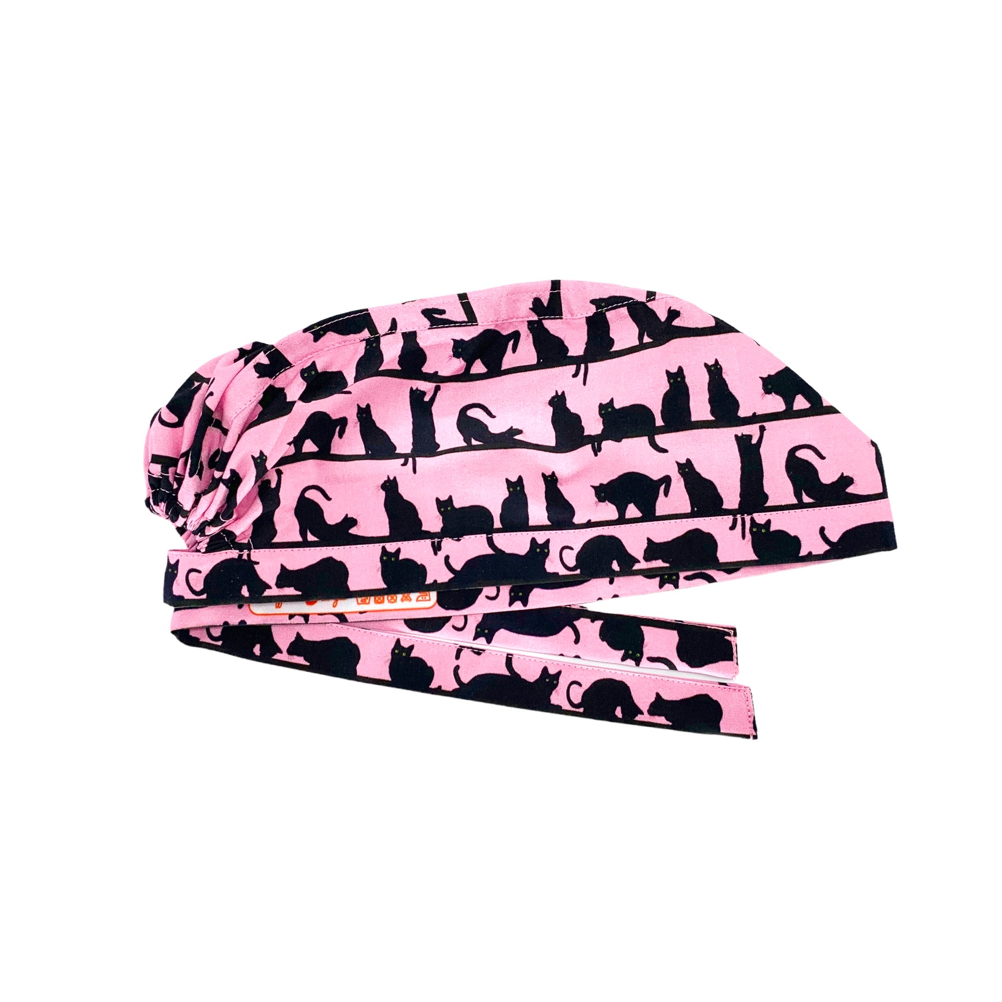 Cuffietta chirurgica con file di piccoli gatti neri realistici in pose tipicamente feline, sfondo rosa