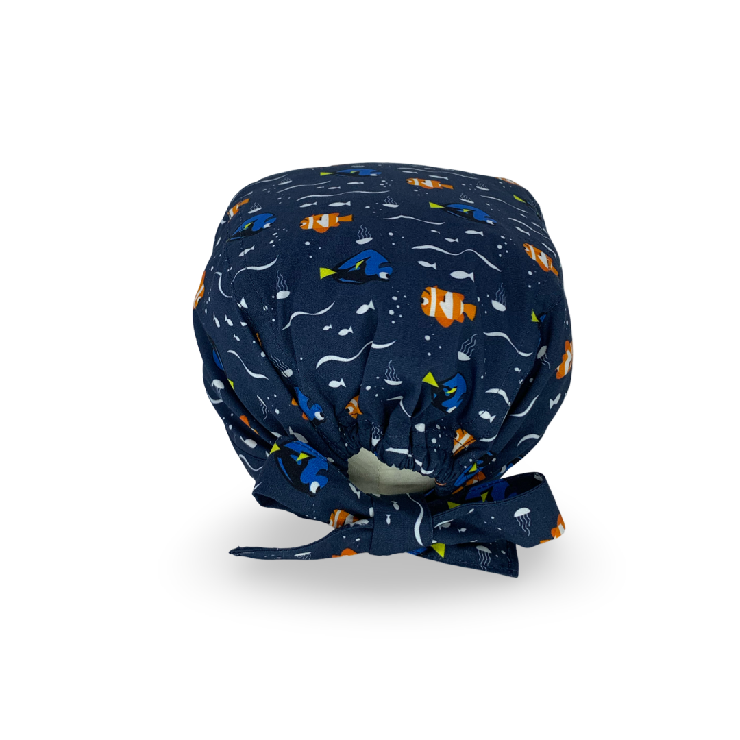 Una cuffietta con sfondo blu scuro e un semplice pattern con un pesce arancione e un pesce blu, entrambi sorridenti. Il mare e i pesci, un binomio infallibile per mettere a proprio agio anche il più ansioso dei pazienti!