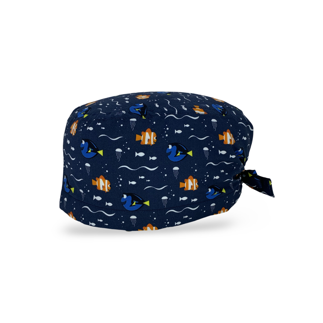 Una cuffietta con sfondo blu scuro e un semplice pattern con un pesce arancione e un pesce blu, entrambi sorridenti. Il mare e i pesci, un binomio infallibile per mettere a proprio agio anche il più ansioso dei pazienti!