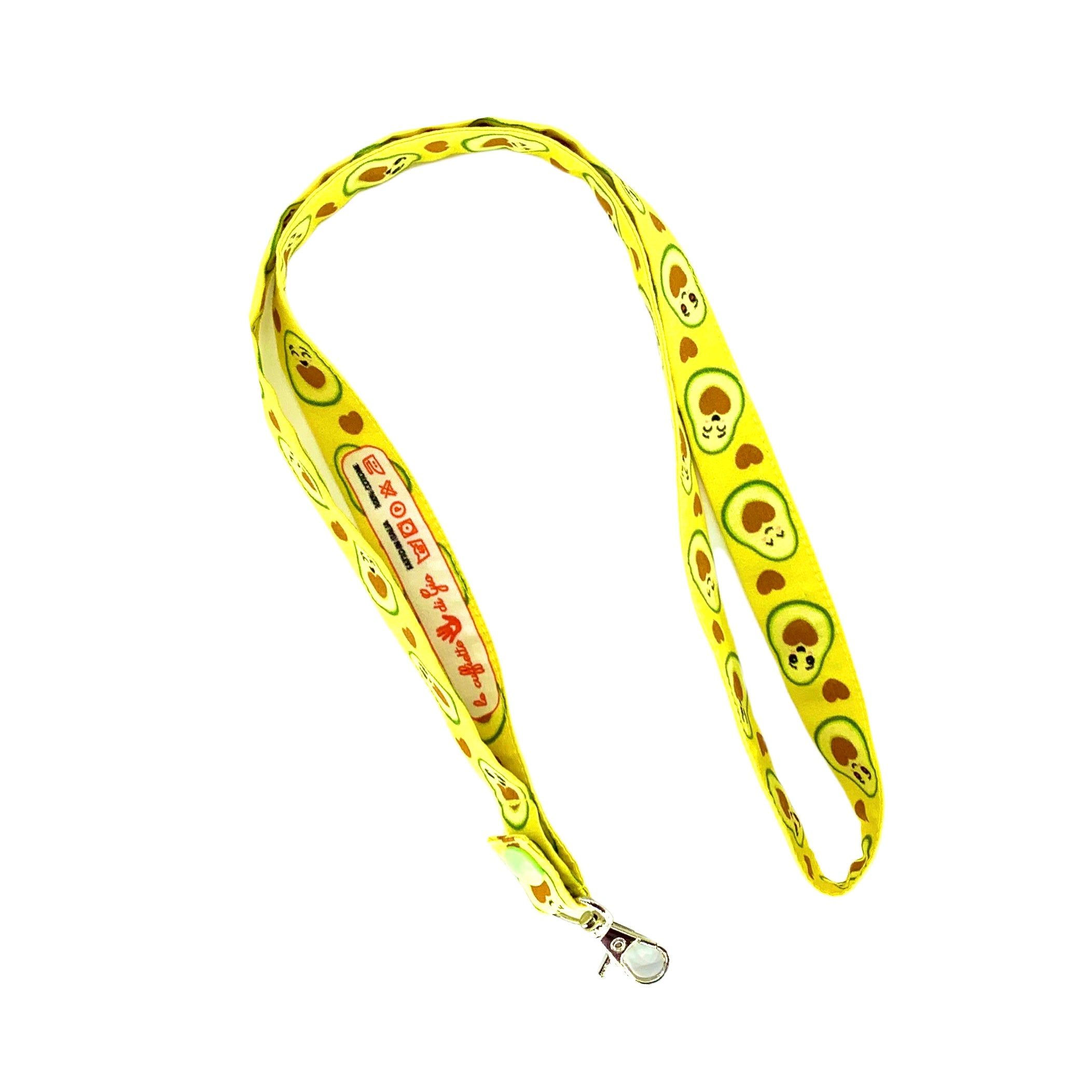 Una fascetta da collo portabadge simpatici avocado tagliati a metà  svelano un cuore morbido, deliziose tonalità  di verde e marrone che si abbinano perfettamente sulla base giallo limone.